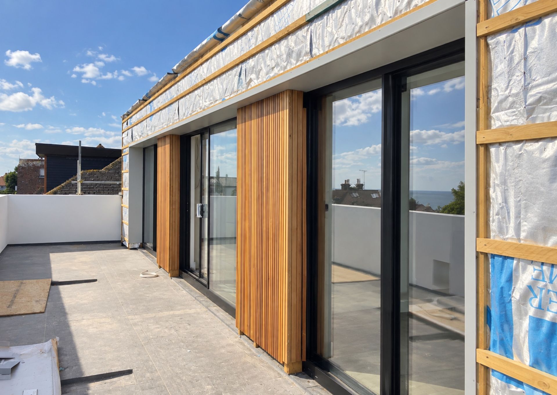 Vertical cedar cladding between sliding doors on a roof terrace
